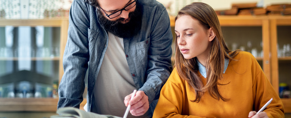 Teacher working with adolescent student